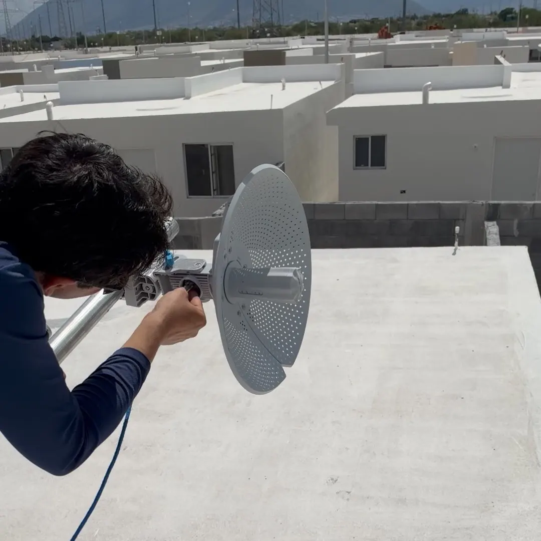 Técnico de Totalnet orientando la antena en el techo de una casa